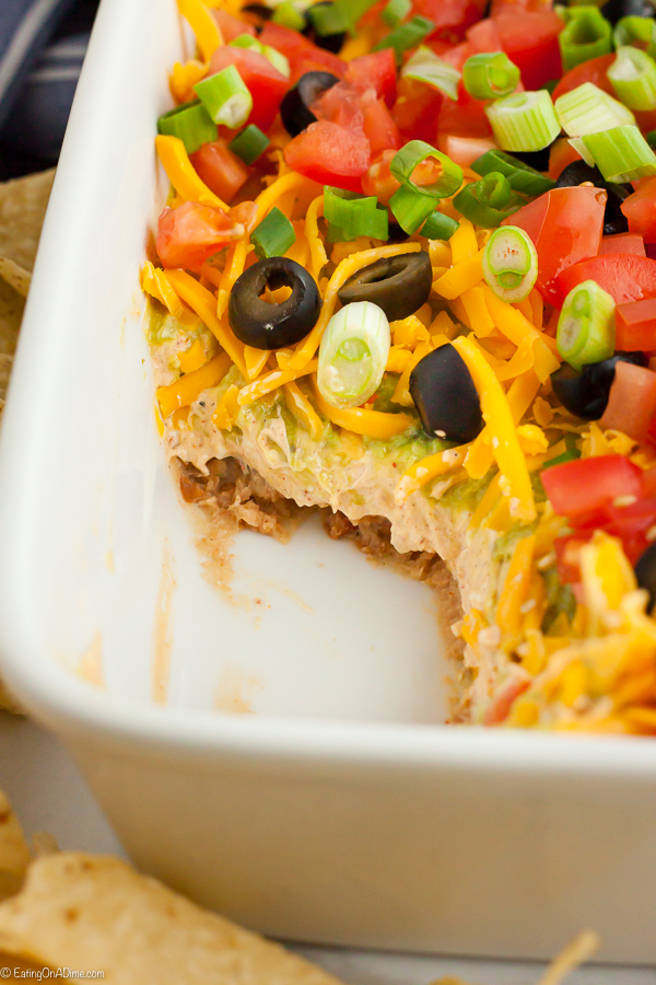 7 layer dip recipe is a crowd pleaser and easy to make. Layers of refried beans, salsa, guacamole and more make this a great dip for parties and tailgating. 