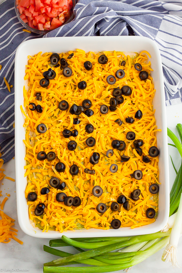 Baking dish layered topped with cheese and slice black olives