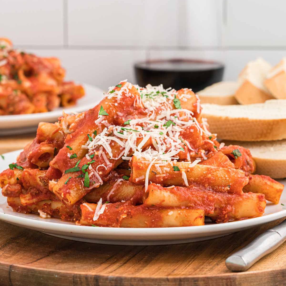 Close up image of baked ziti on a white plate.