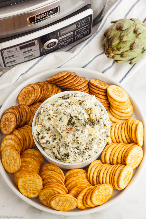 Spinach dip in a platter with crackers