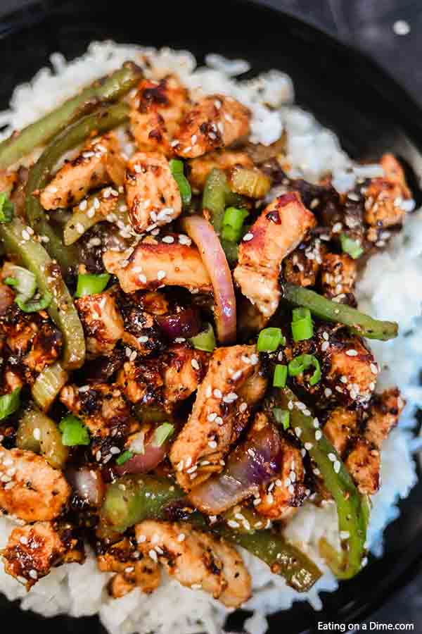 Close up image of black pepper chicken on rice.
