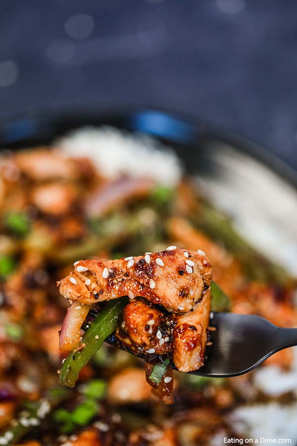Close up image of black pepper chicken with a serving on a fork.