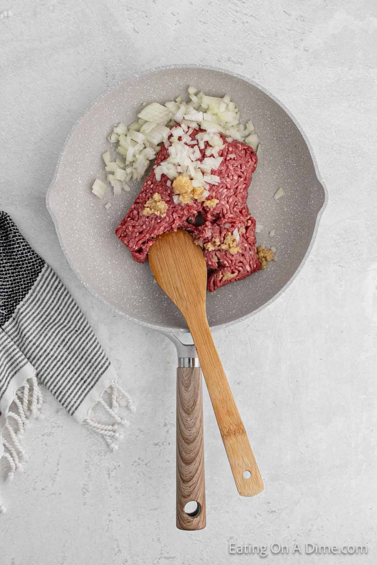 Cooking the ground beef with onions in a skillet