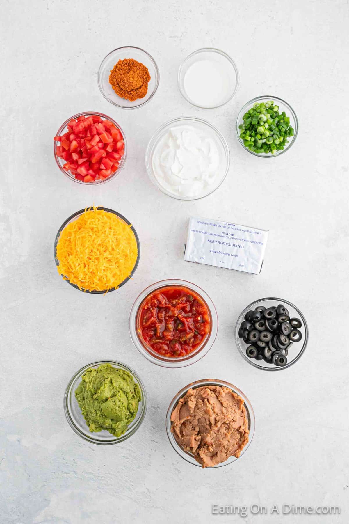 Ingredients - Salsa, refried beans, milk, cream cheese, sour cream, taco seasoning, guacamole, cheese, black olives, roma tomatoes, green onions
