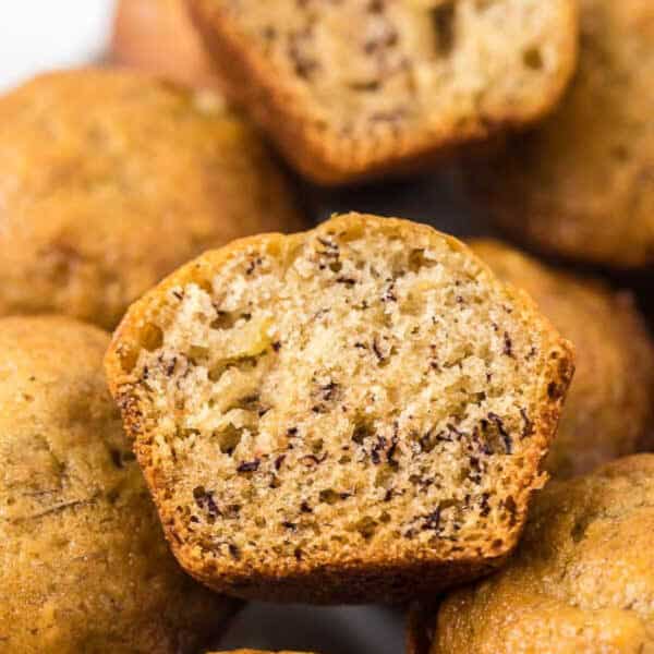 Muffins stacked on top of each other with 1 cut in half.