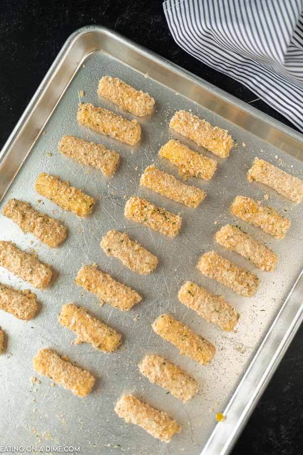 cheese sticks lined on a baking sheet