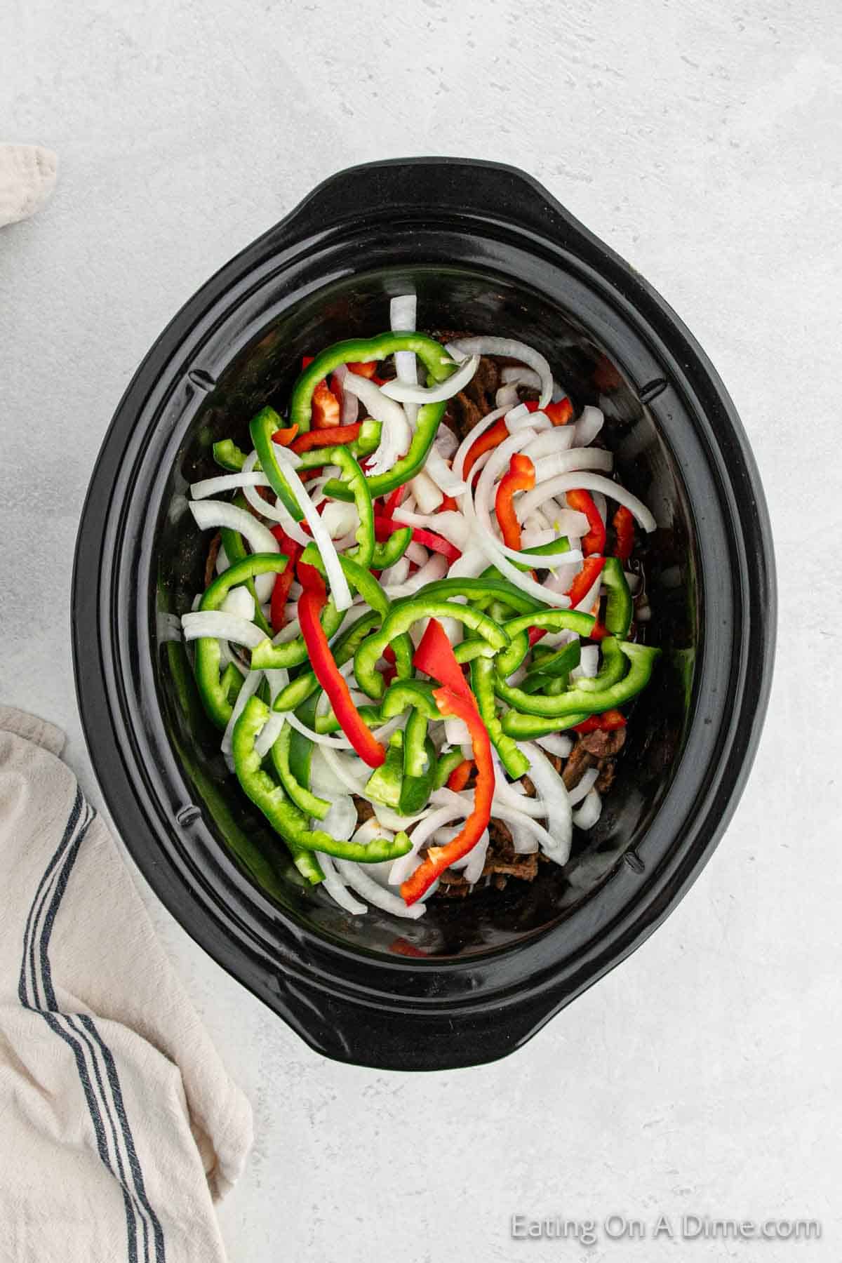 Slice bell peppers and onions layered in the slow cooker