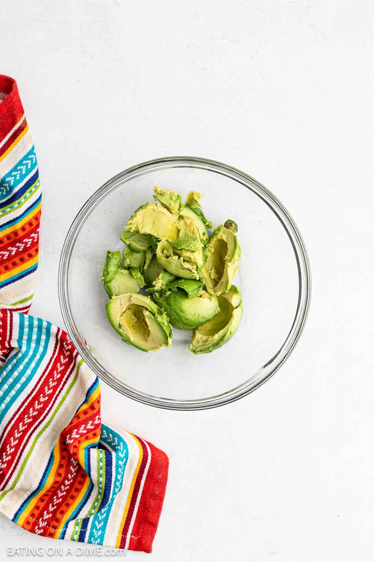 Sliced and peeled avocados in a bowl.