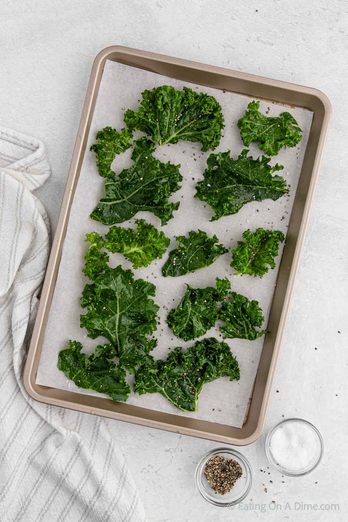 Arranging the kale leaves on a baking sheet being seasoned