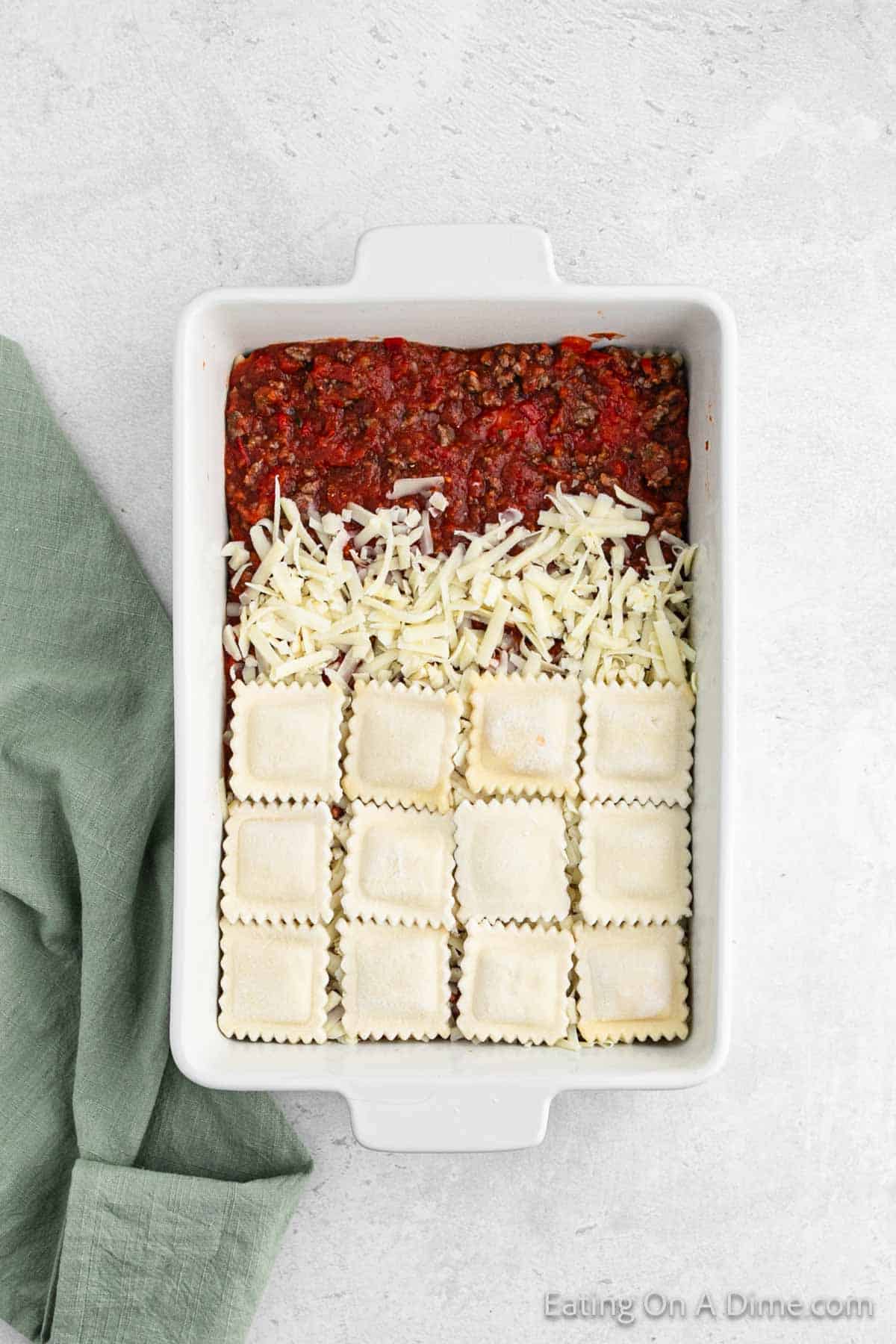 Layering the ground beef mixture, cheese and ravioli in the baking dish