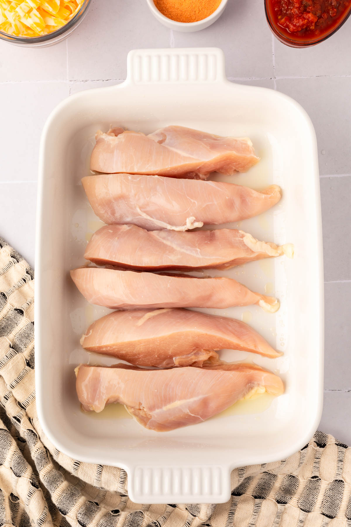 Placing sliced chicken in baking dish