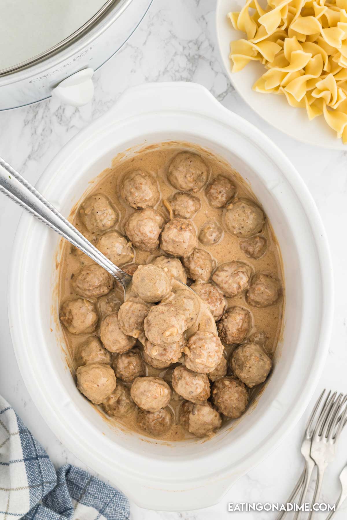Swedish meatballs in slow cooker with a serving on a spoon