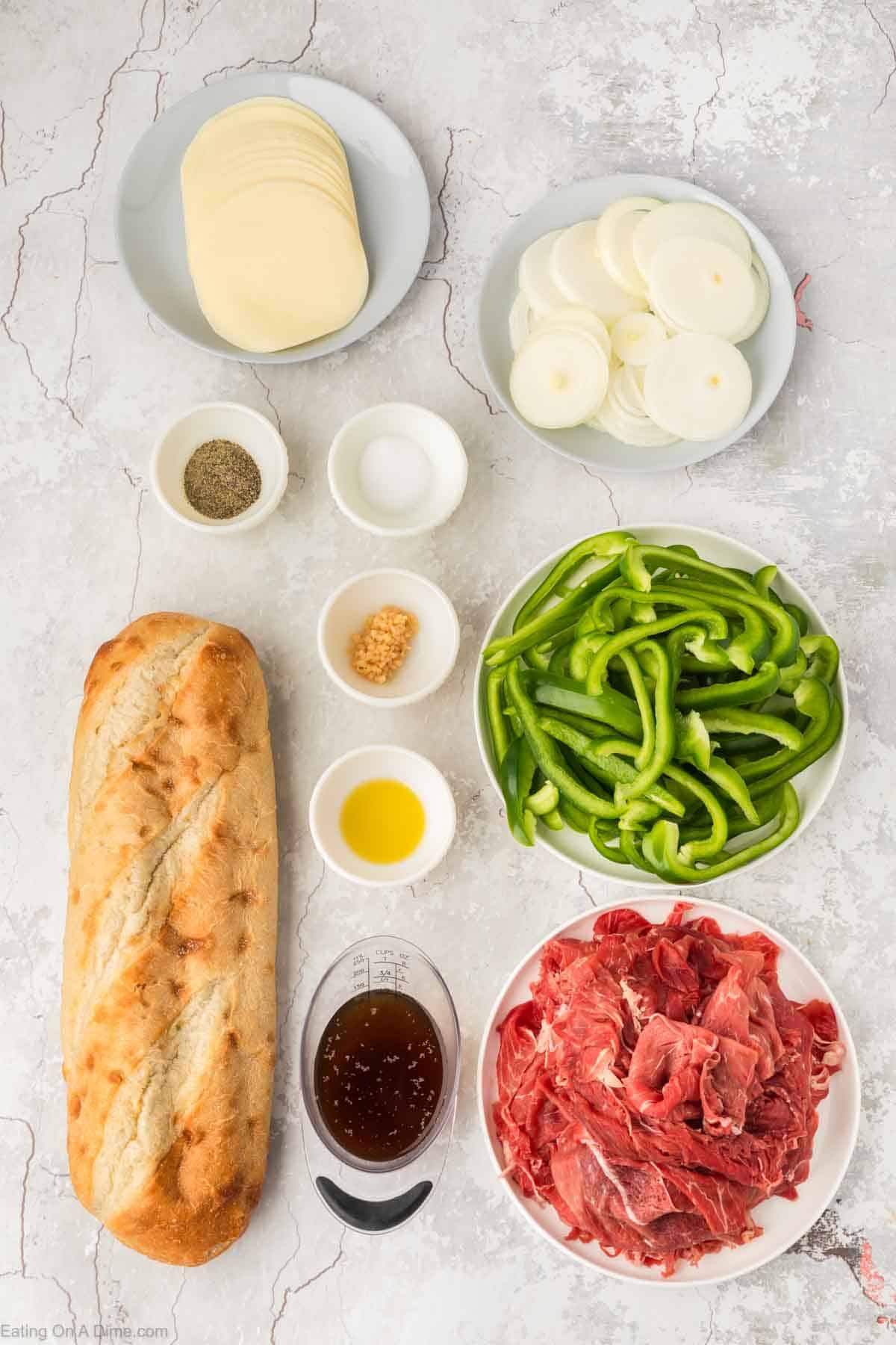Cheesesteak Bread ingredients - oil, sirloin steak, green bell peppers, white onion, garlic, salt, pepper, beef broth, provolone cheese, French Bread
