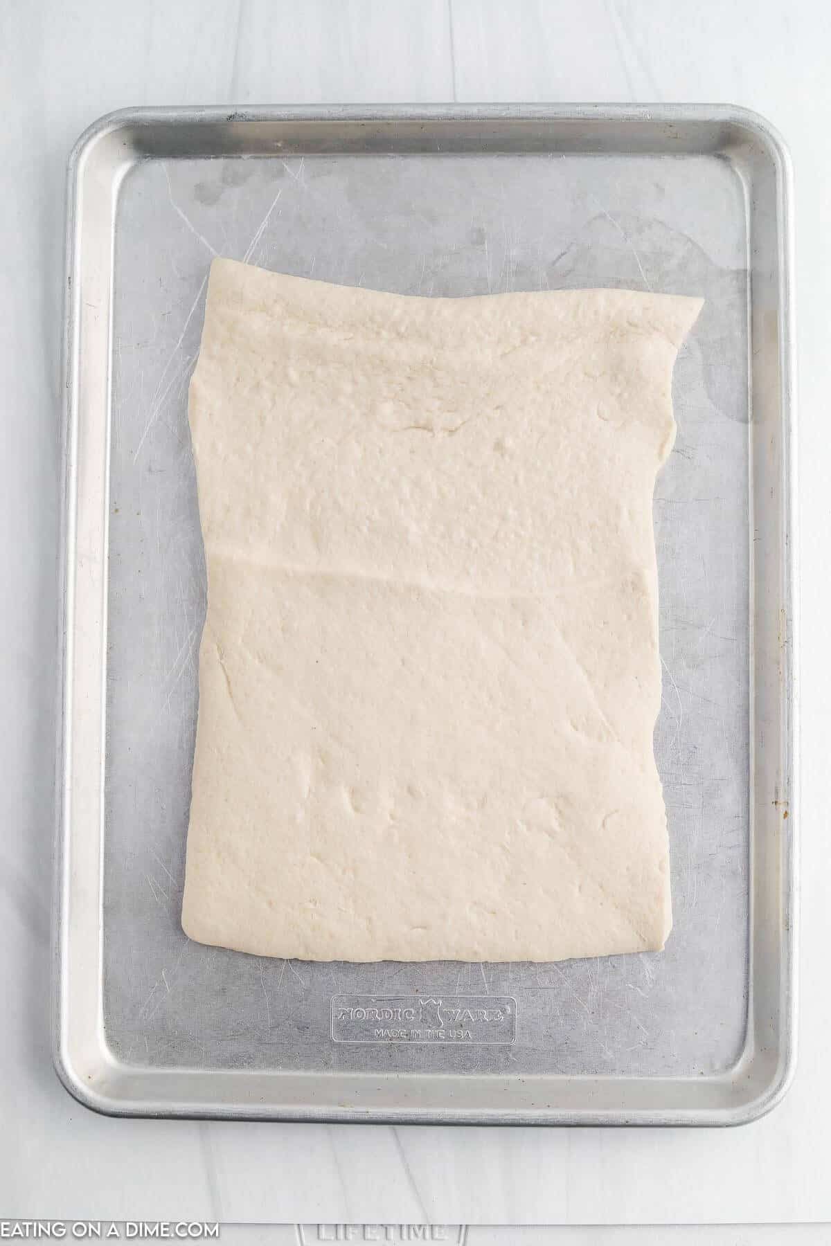 Roll out the pizza dough onto on a baking sheet