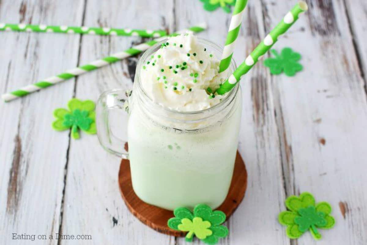 Close up image of shamrock shake topped with whipped cream and sprinkles