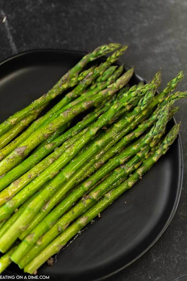 Roasted asparagus on a black plate 
