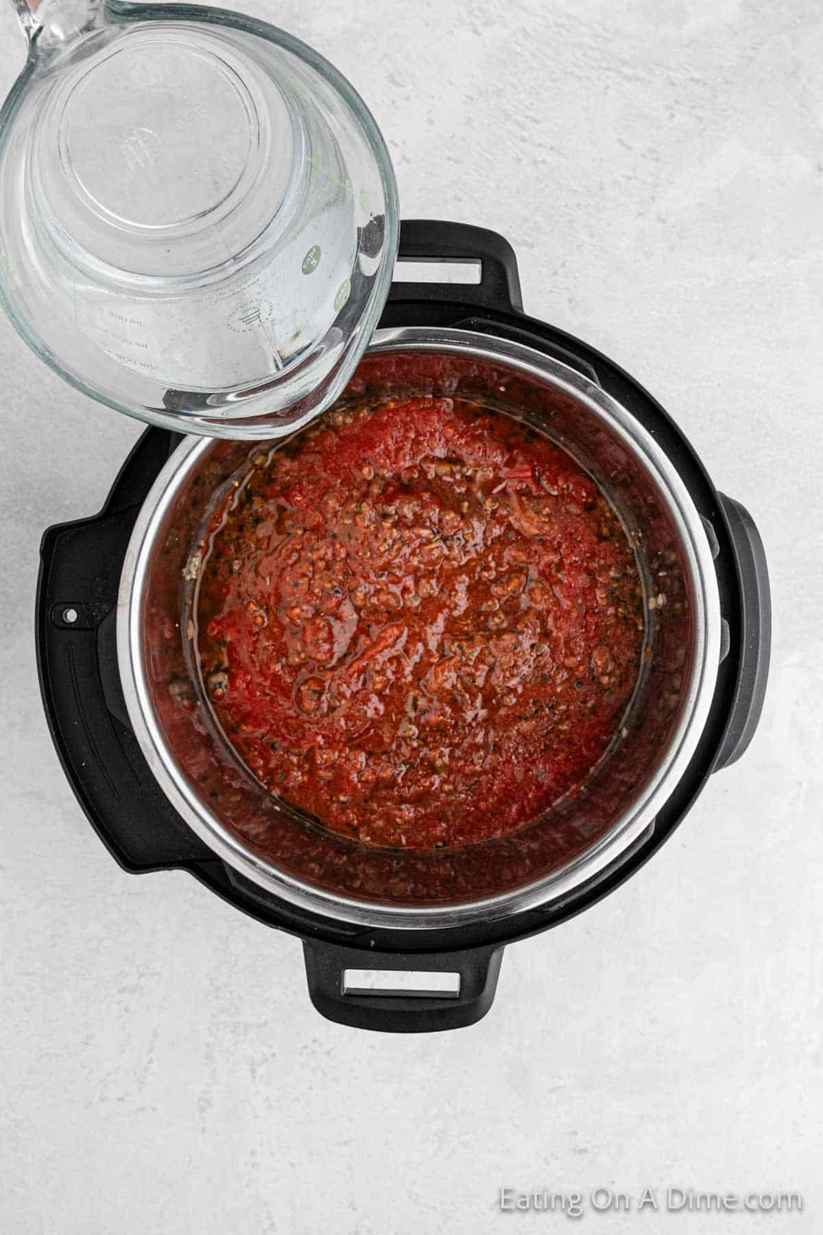 Adding in the sauce with water into the instant pot