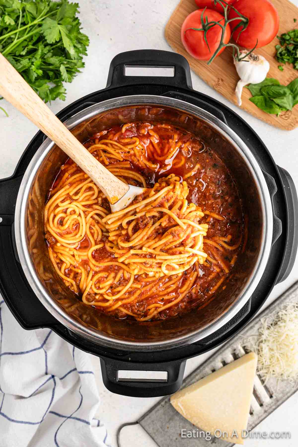 Spaghetti in the instant pot with a wooden spoon