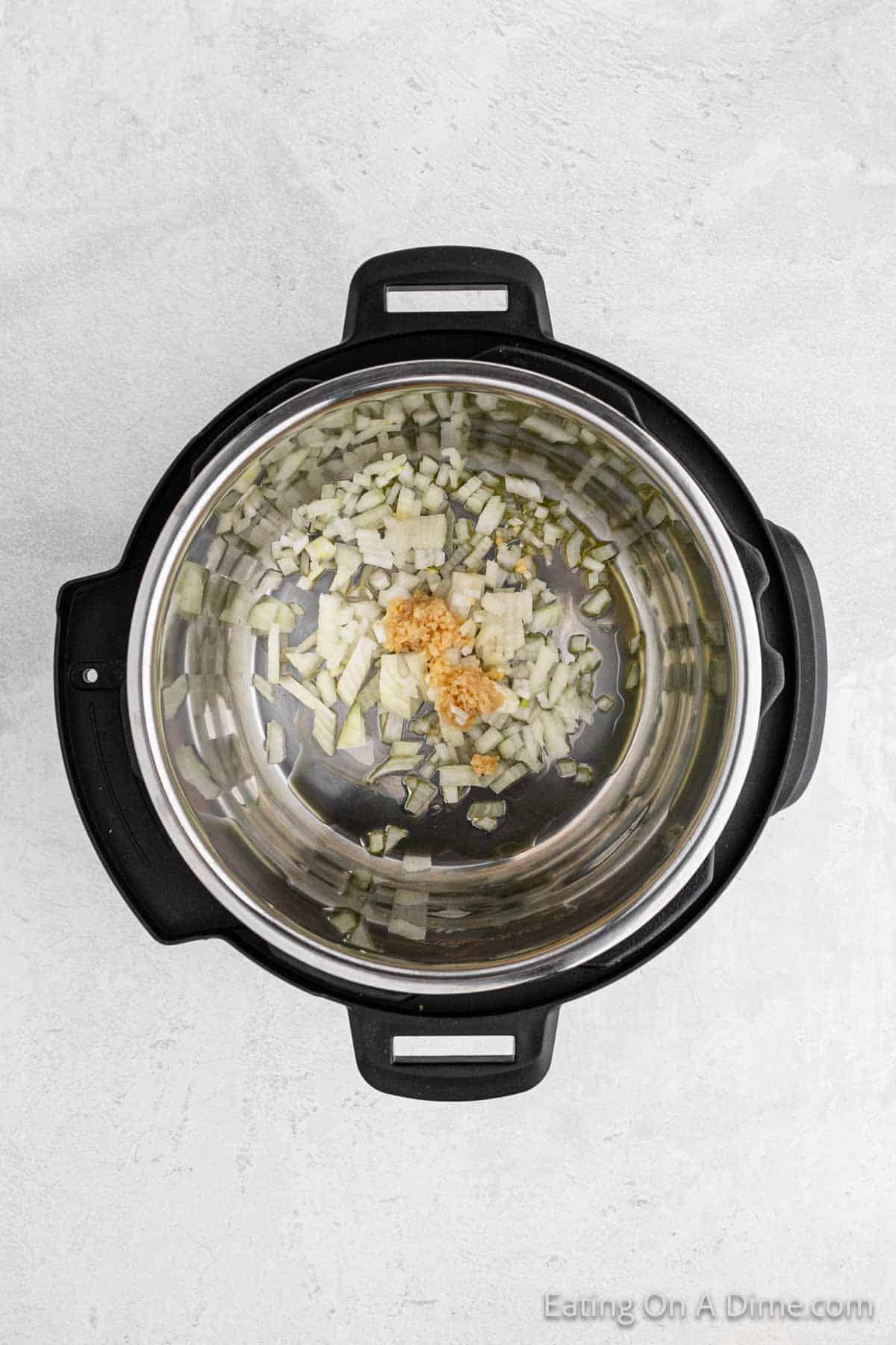 Placing the chopped onions and garlic in the instant pot