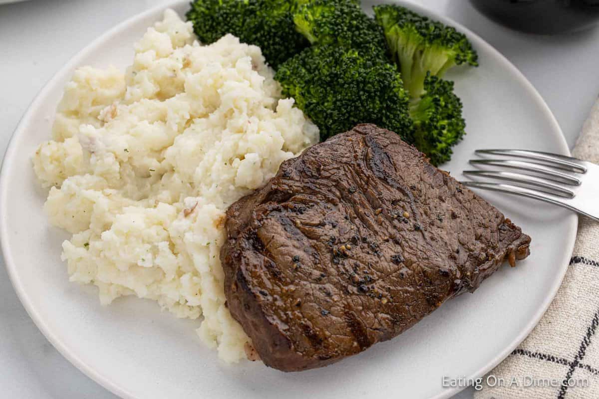 Grilled steak on a plate with mashed potatoes and broccoli