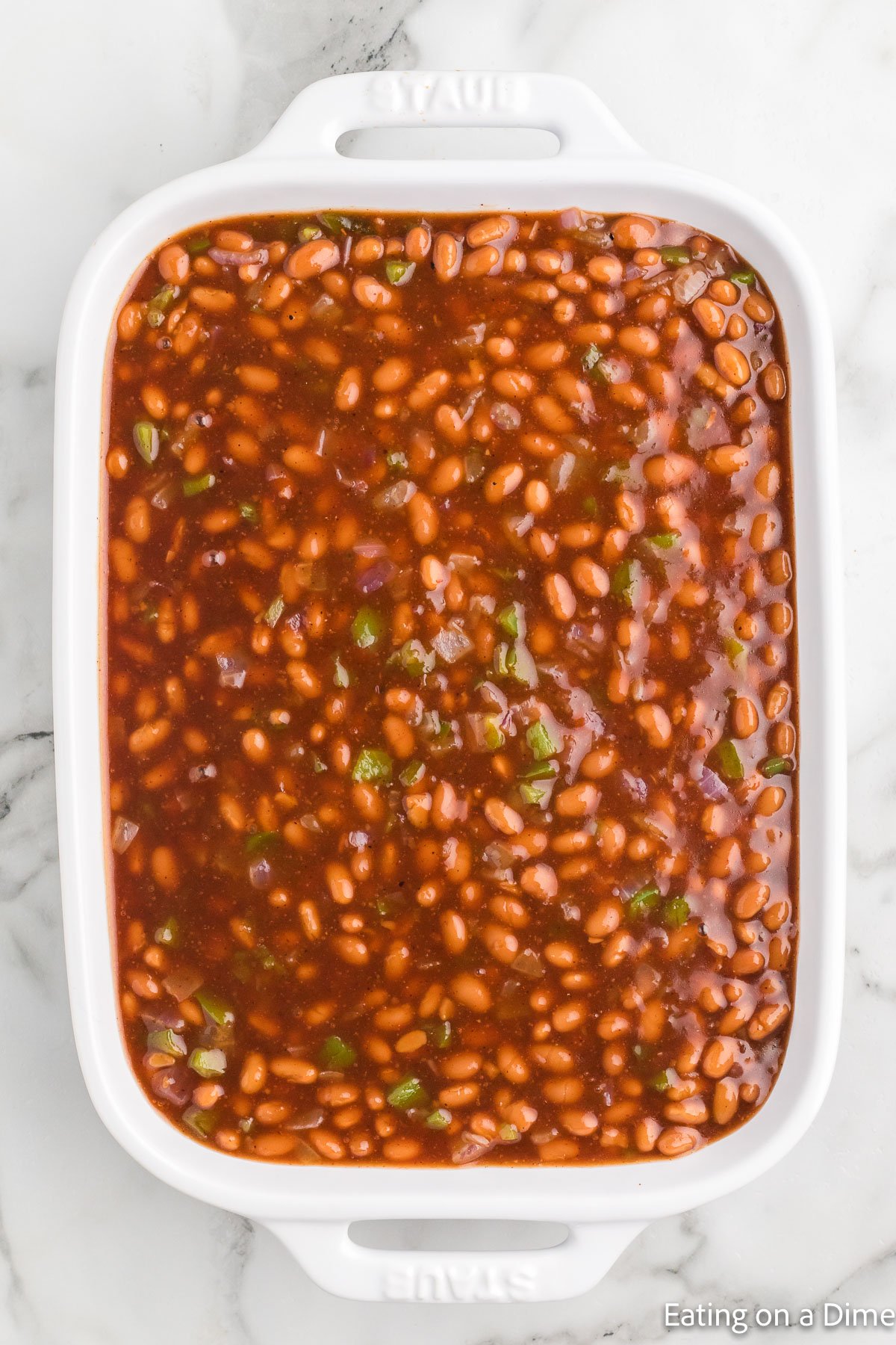 Pouring the baked beans into a baking dish