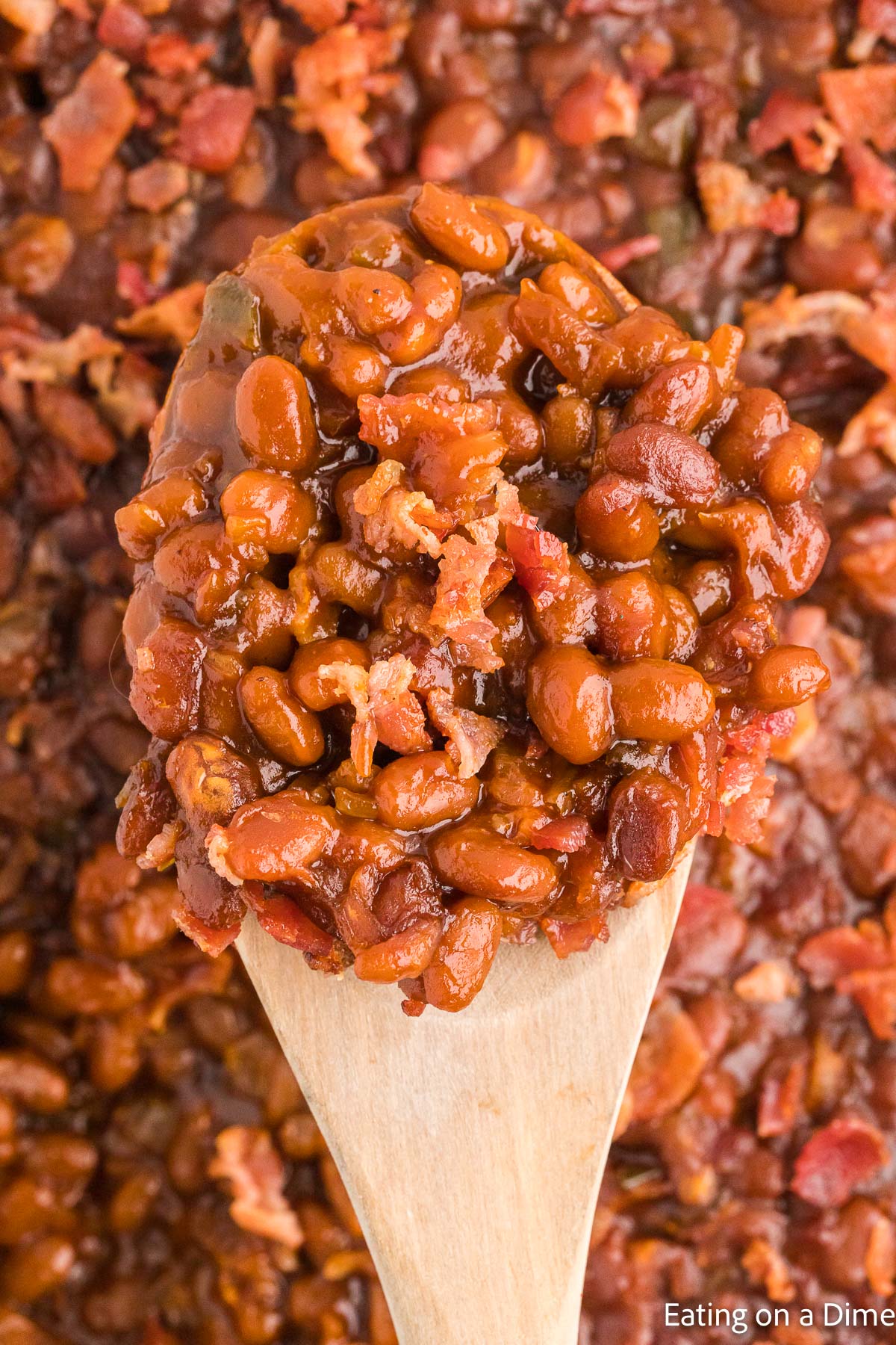 Close up image of baked beans on a wooden spoon