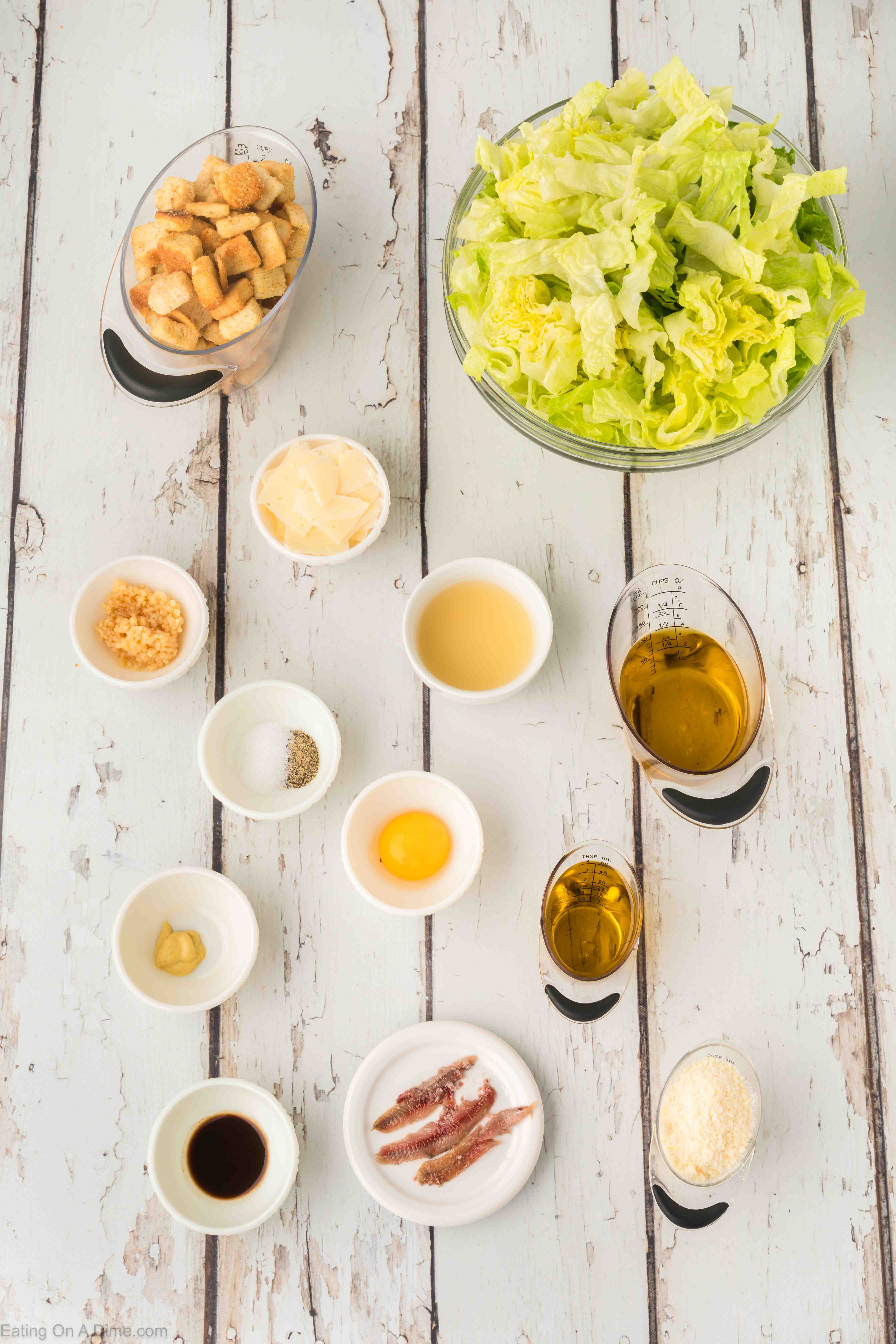 Caesar Salad Dressing Ingredients - anchovy fillets, minced garlic, worcestershire sauce, egg yolk, lemon juice, dijon mustard, olive oil, vegetable oil, grated parmesan, salt and pepper, croutons, romaine hearts, parmesan cheese