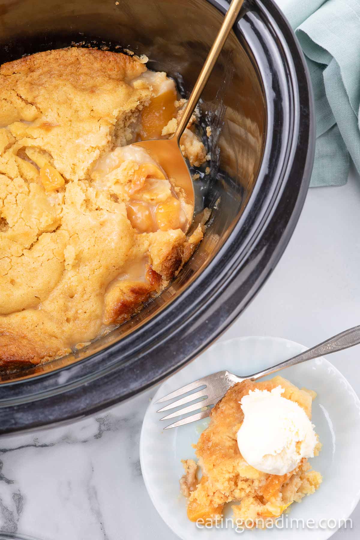 Peach Dump Cake in the slow cooker with a serving on a spoon