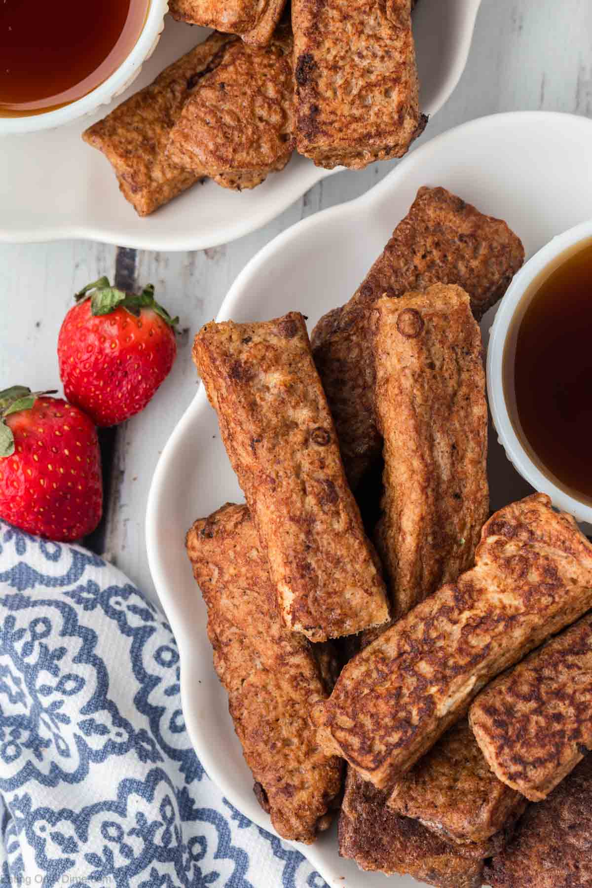 French Toast Sticks on a white platter with a side of maple syrup