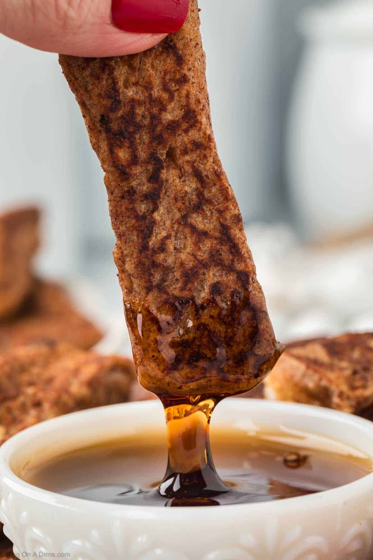 Dipping the French Toast Sticks into the maple syrup