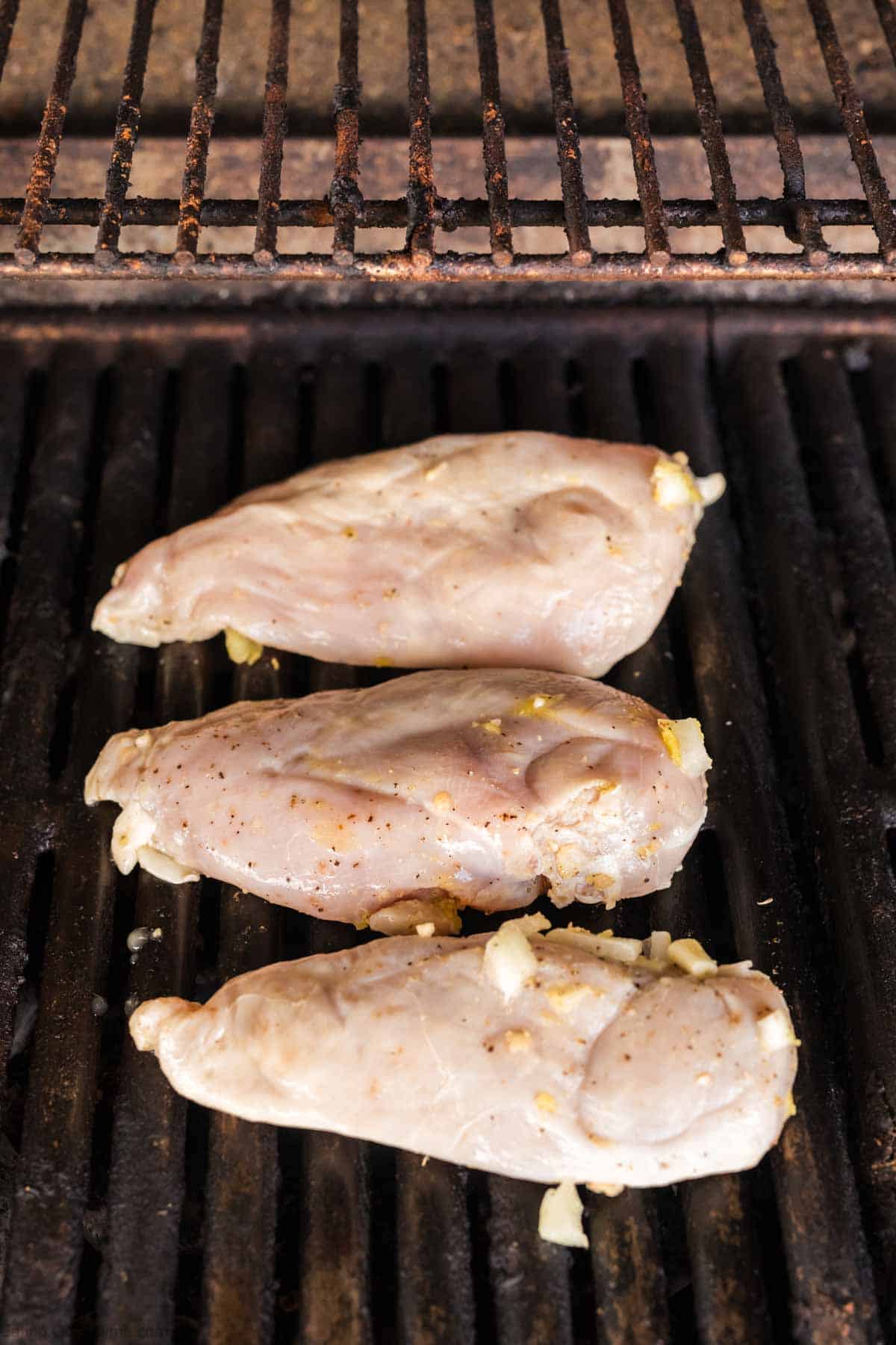 Marinated chicken breast on the grill grates