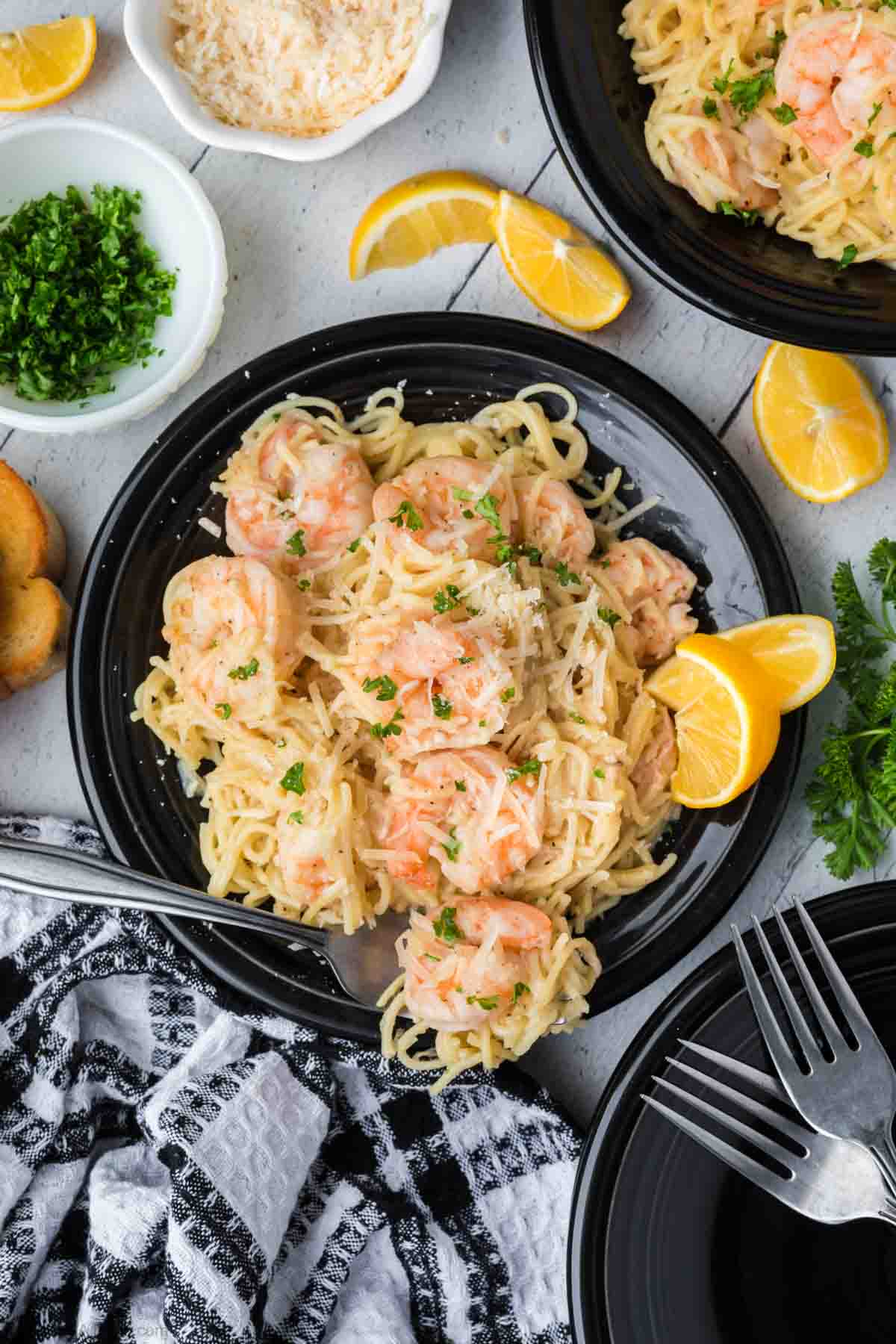 Shrimp scampi with noodles on a plate with slice of oranges
