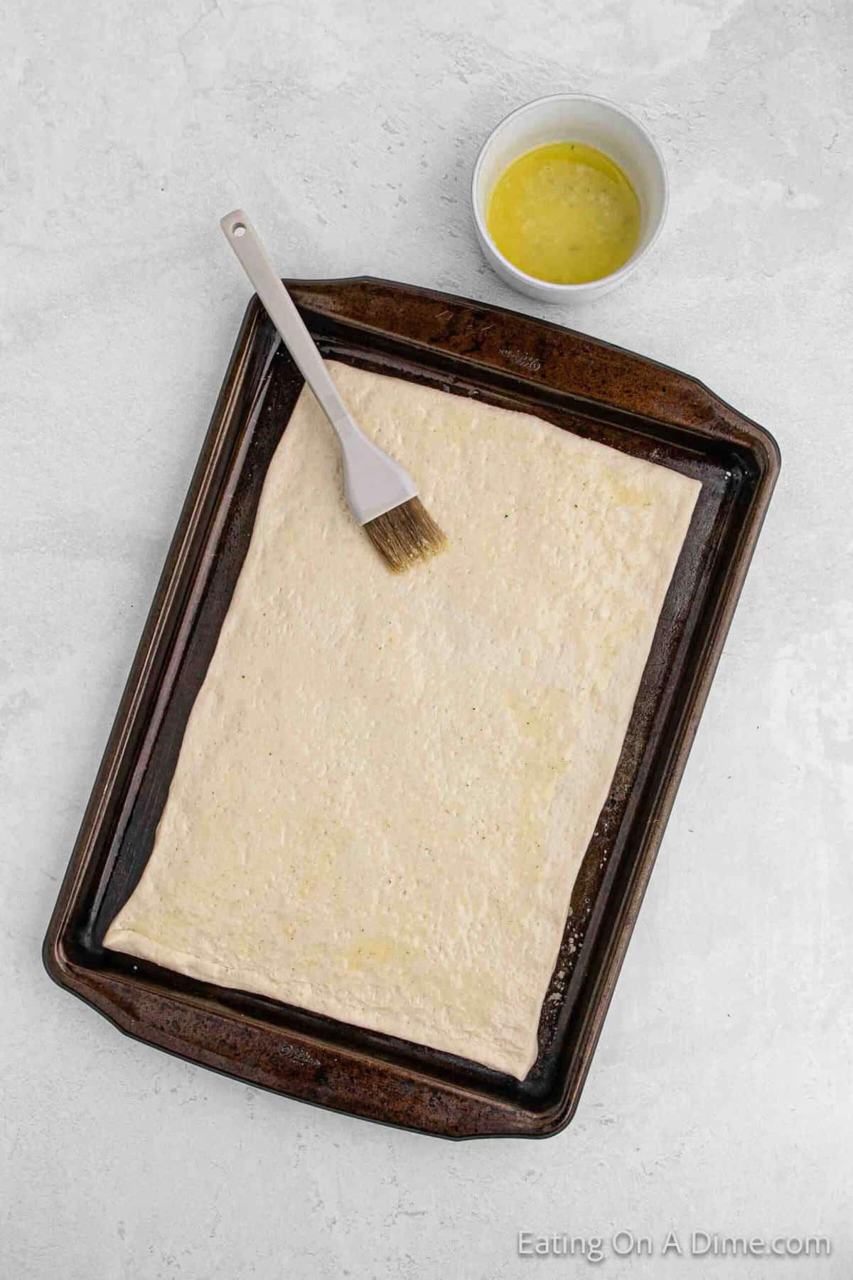 Topping the dough with melted butter