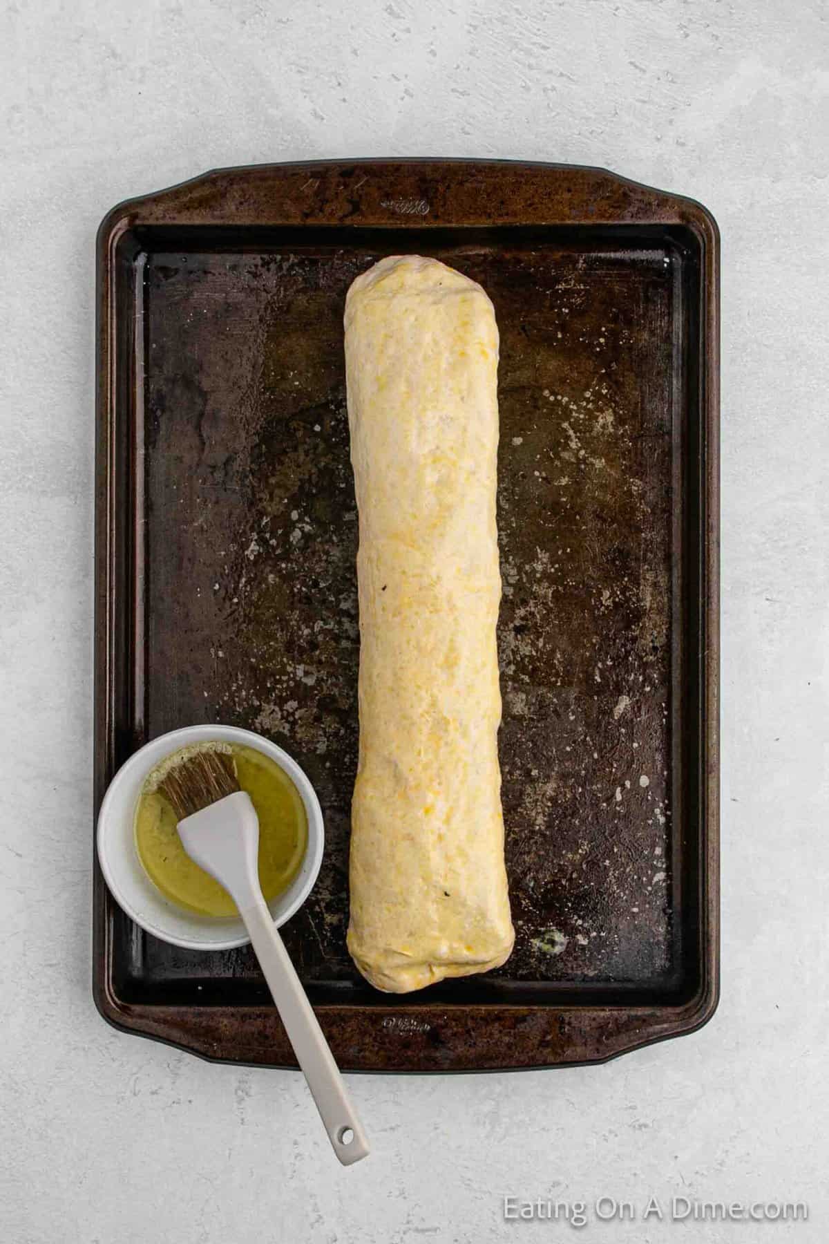 Brushing the rolled dough with melted butter