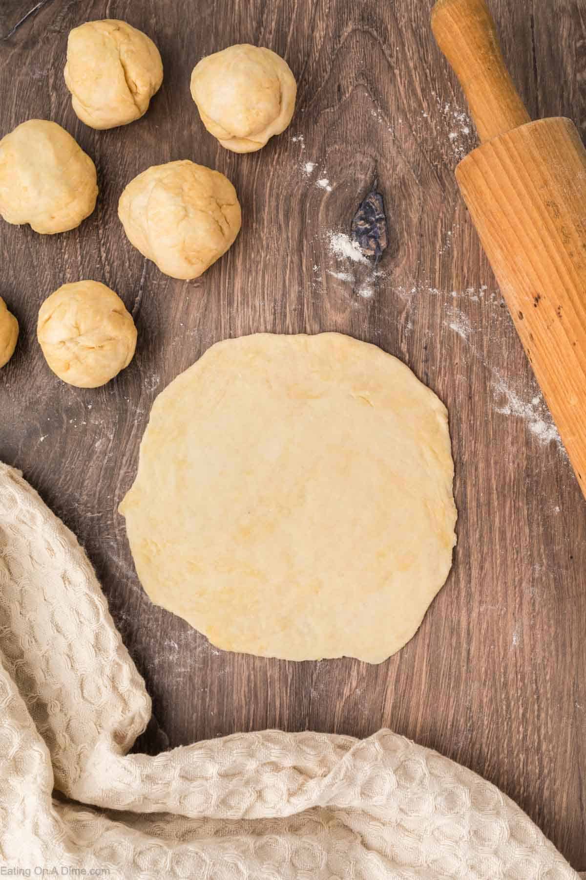Flattening dough balls to make tortilla dough with a rolling pin