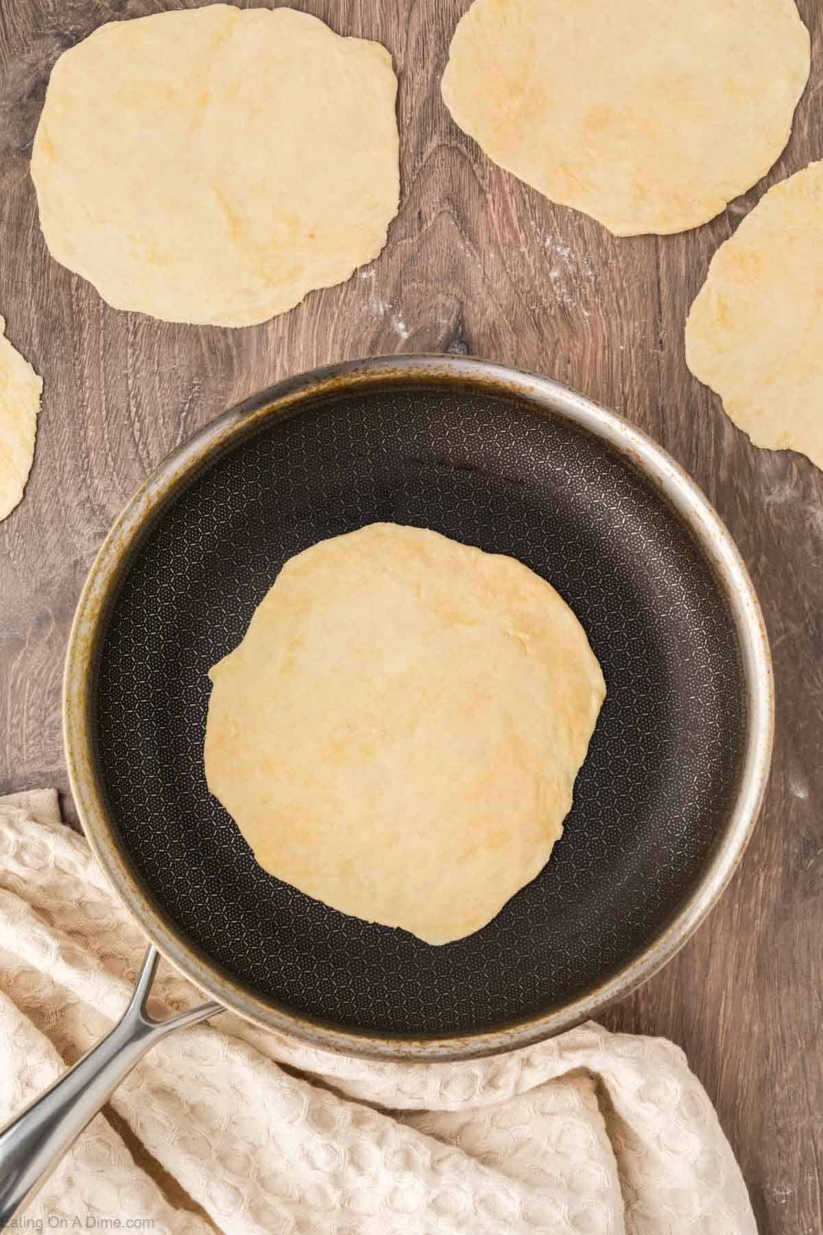 Placing the tortilla in a skillet 