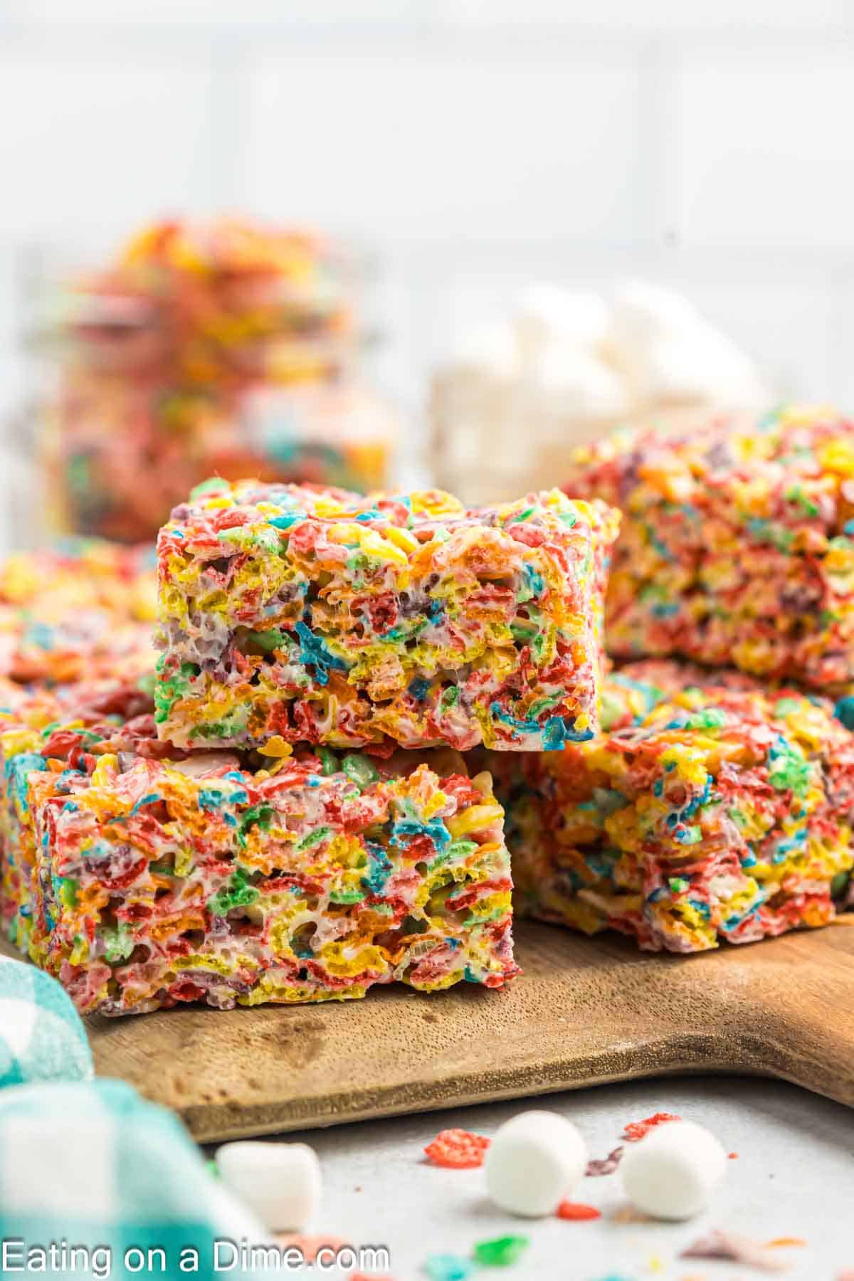 Fruity Pebbles squares stacked on a cutting board
