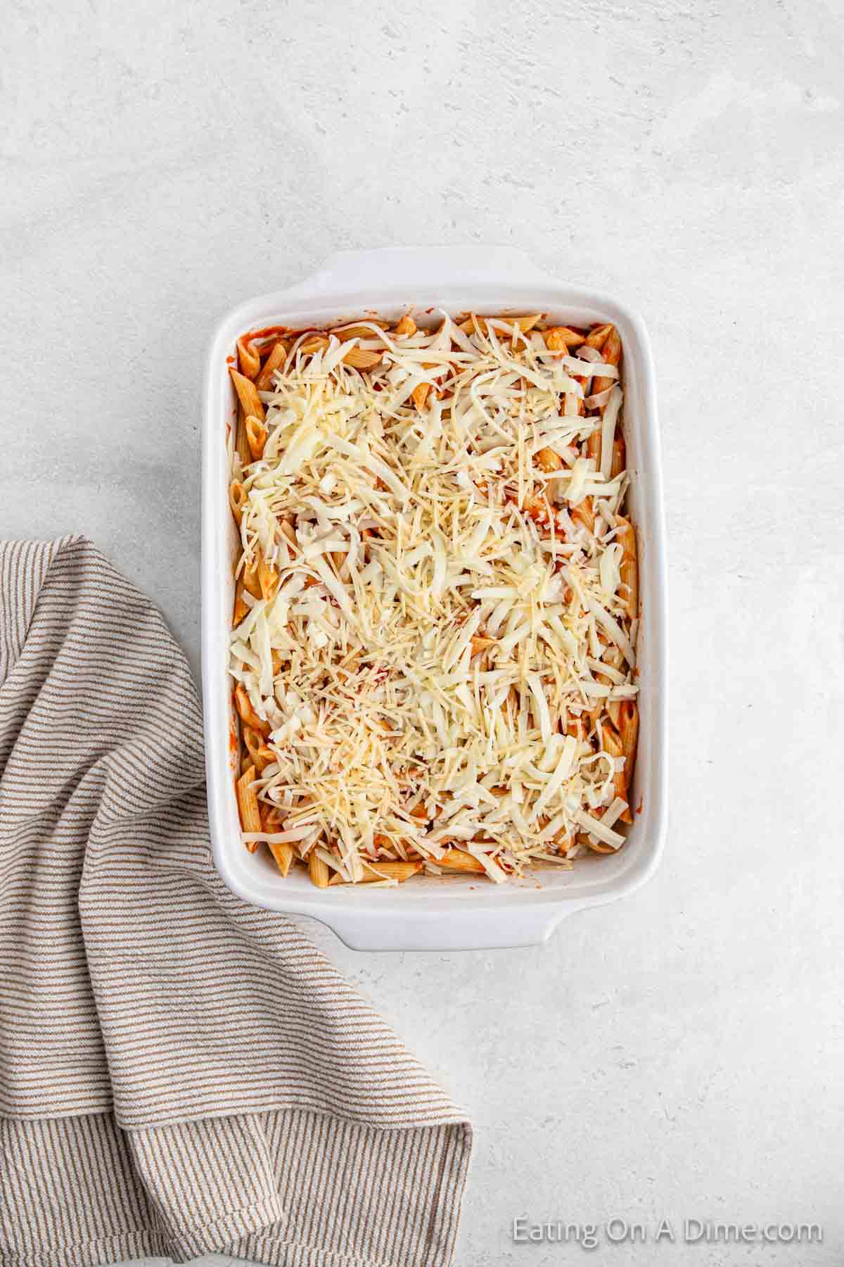 Toping with shredded cheese in the casserole dish