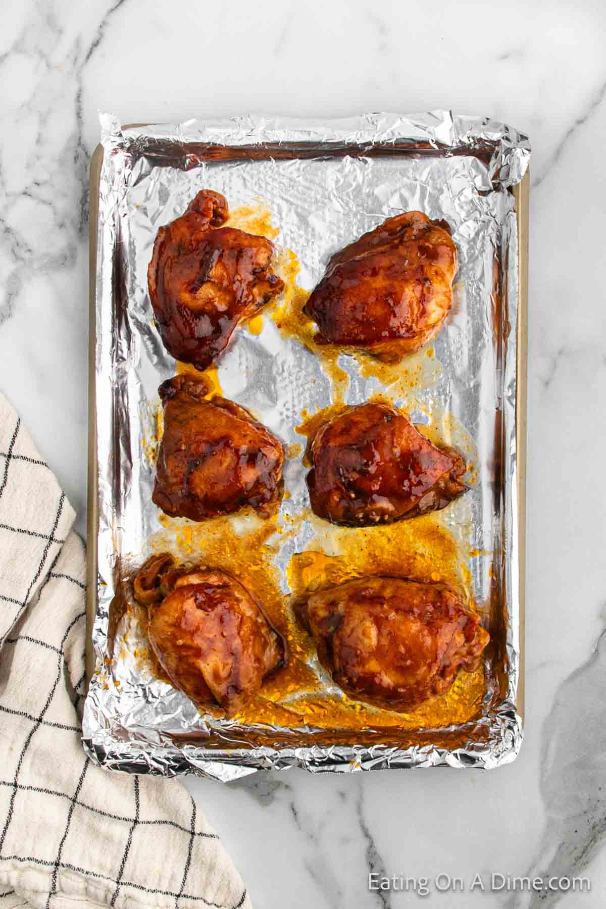 Placing the chicken thighs on a baking sheet and broil
