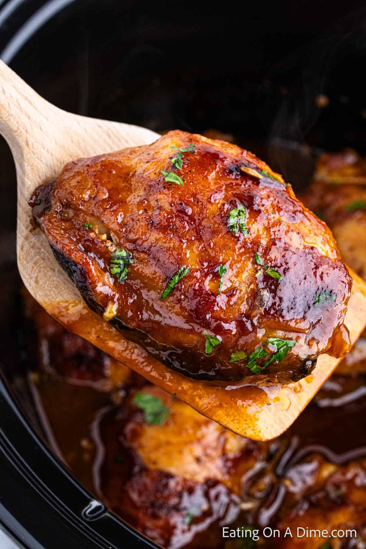Close up image of chicken thighs on a wooden spoon