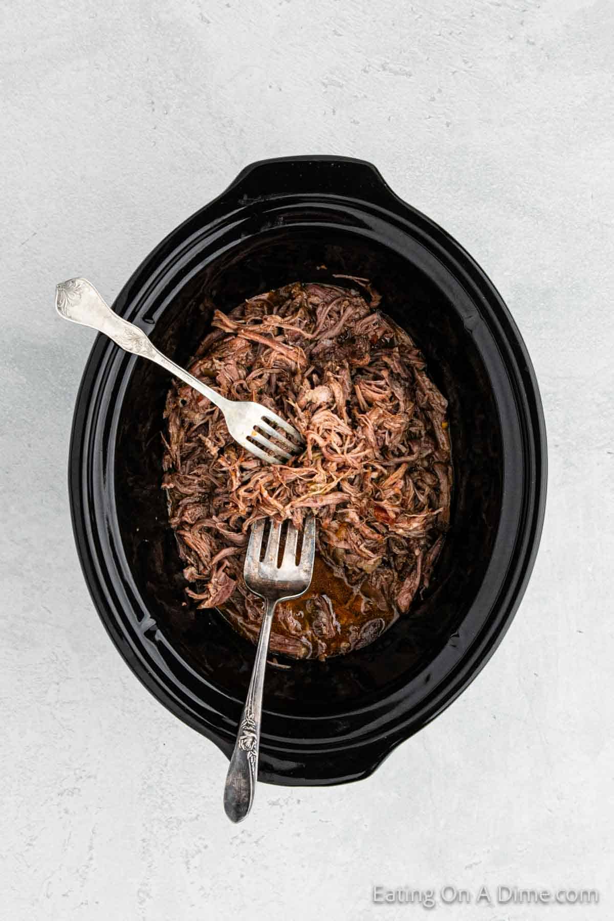 Shredded beef in the slow cooker with two forks