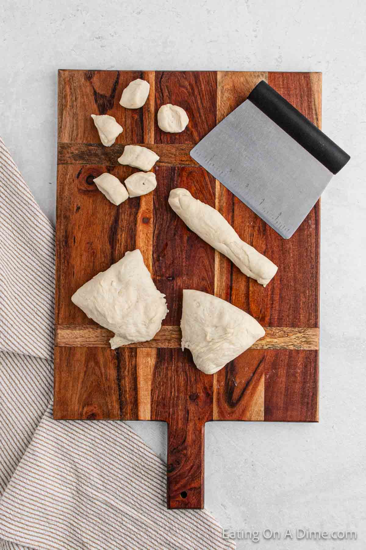 Rolling the dough on a cutting board and cutting into bite size pieces