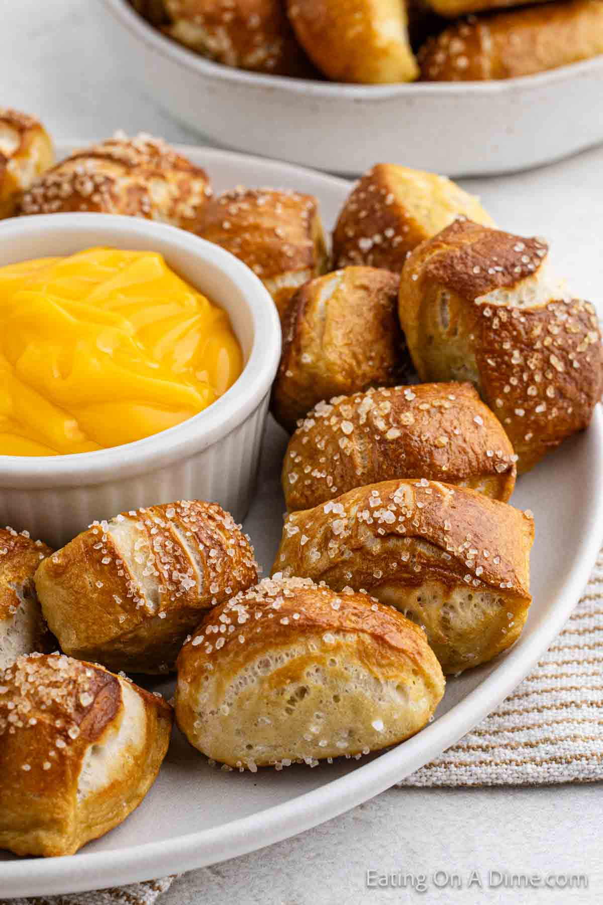 Pretzel Bites on a white plate with a bowl of cheese sauce