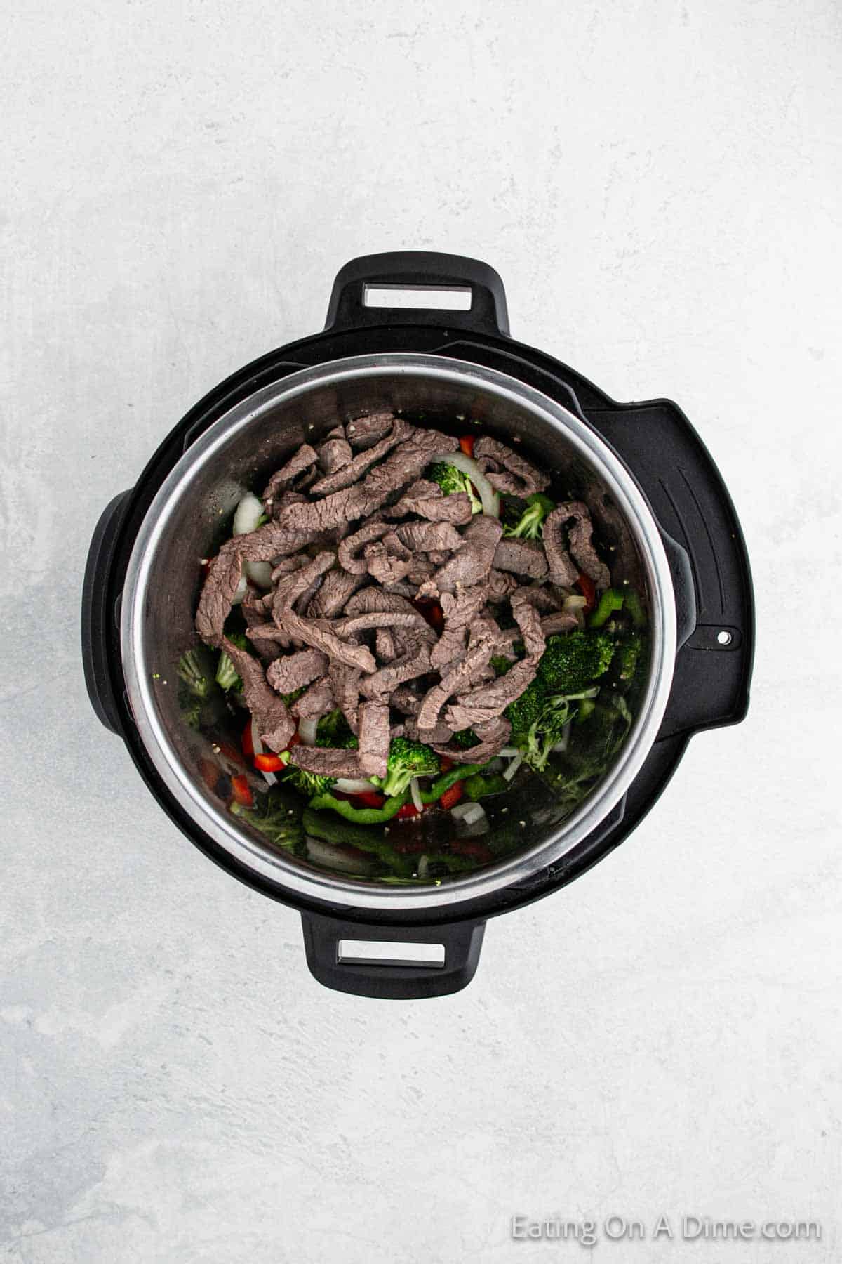 Cooked strips of beef in the instant pot on vegetables