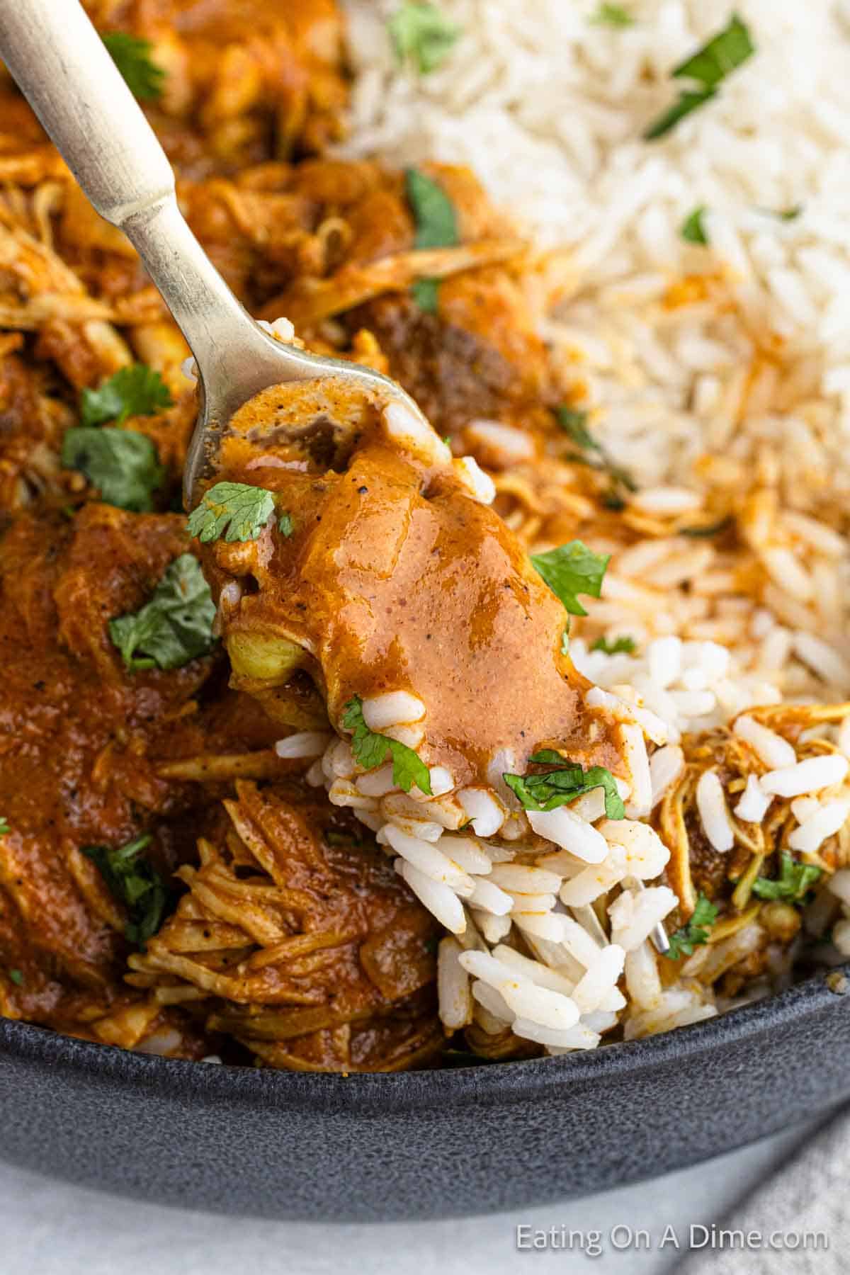 Chicken Tikka Masala in a bowl with white rice with a serving on a fork