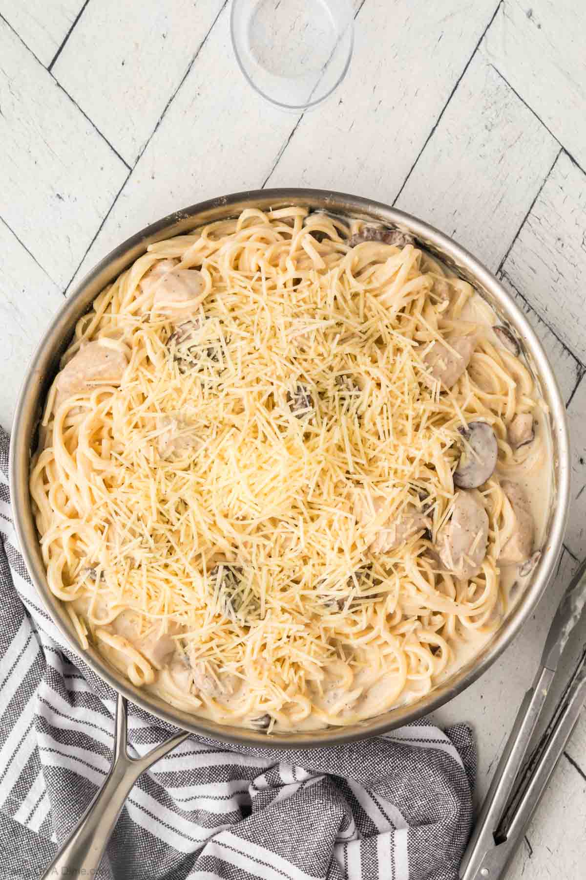 Combining the pasta, chicken and mushrooms into the sauce in a skillet