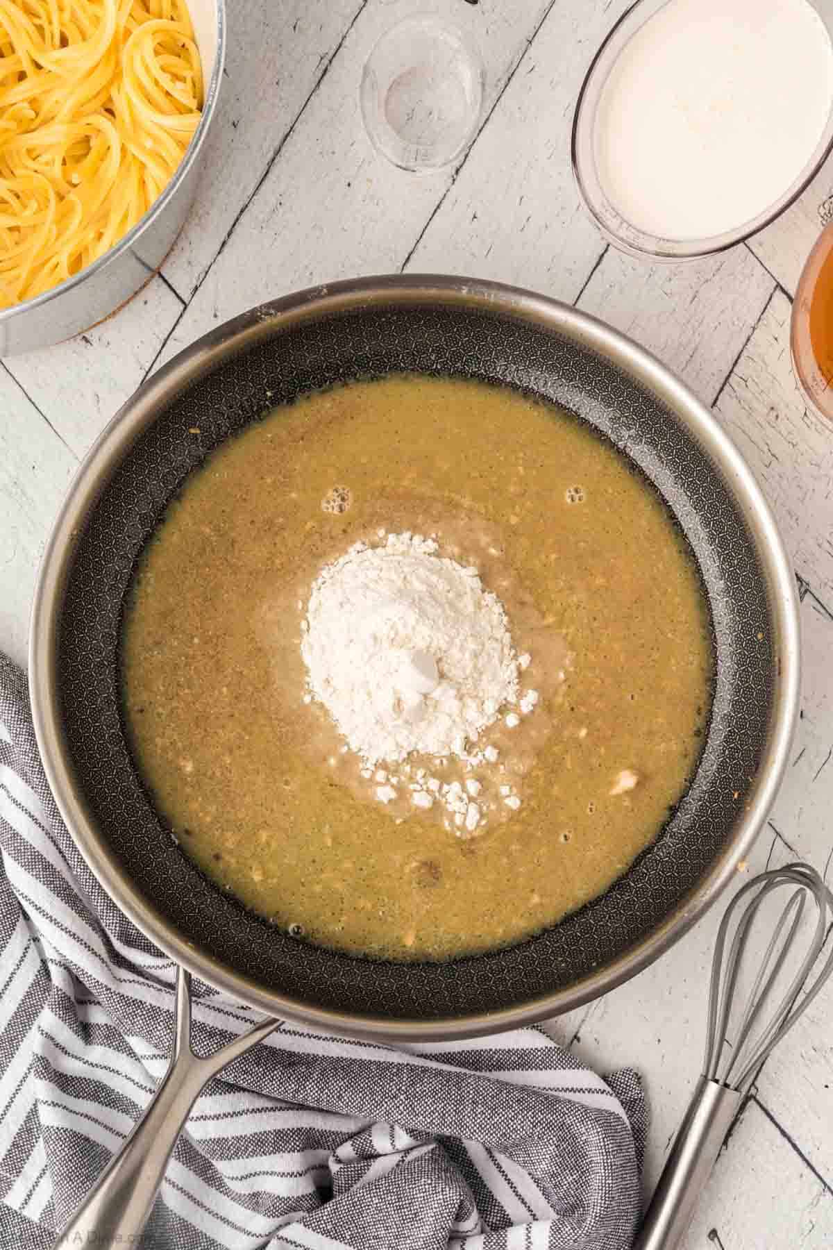 Adding flour to sauce in a skillet