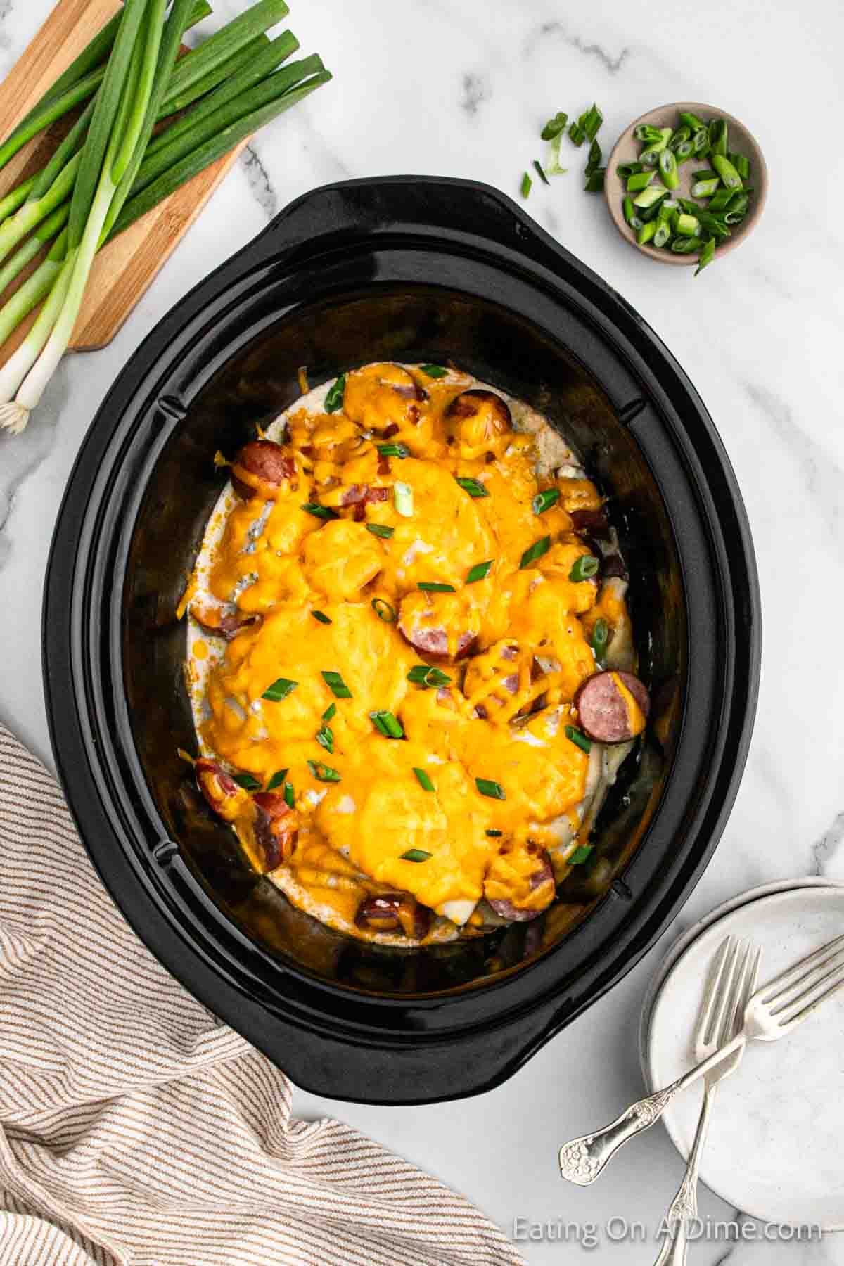 Melted cheese on top of cooked pierogi casserole in the slow cooker