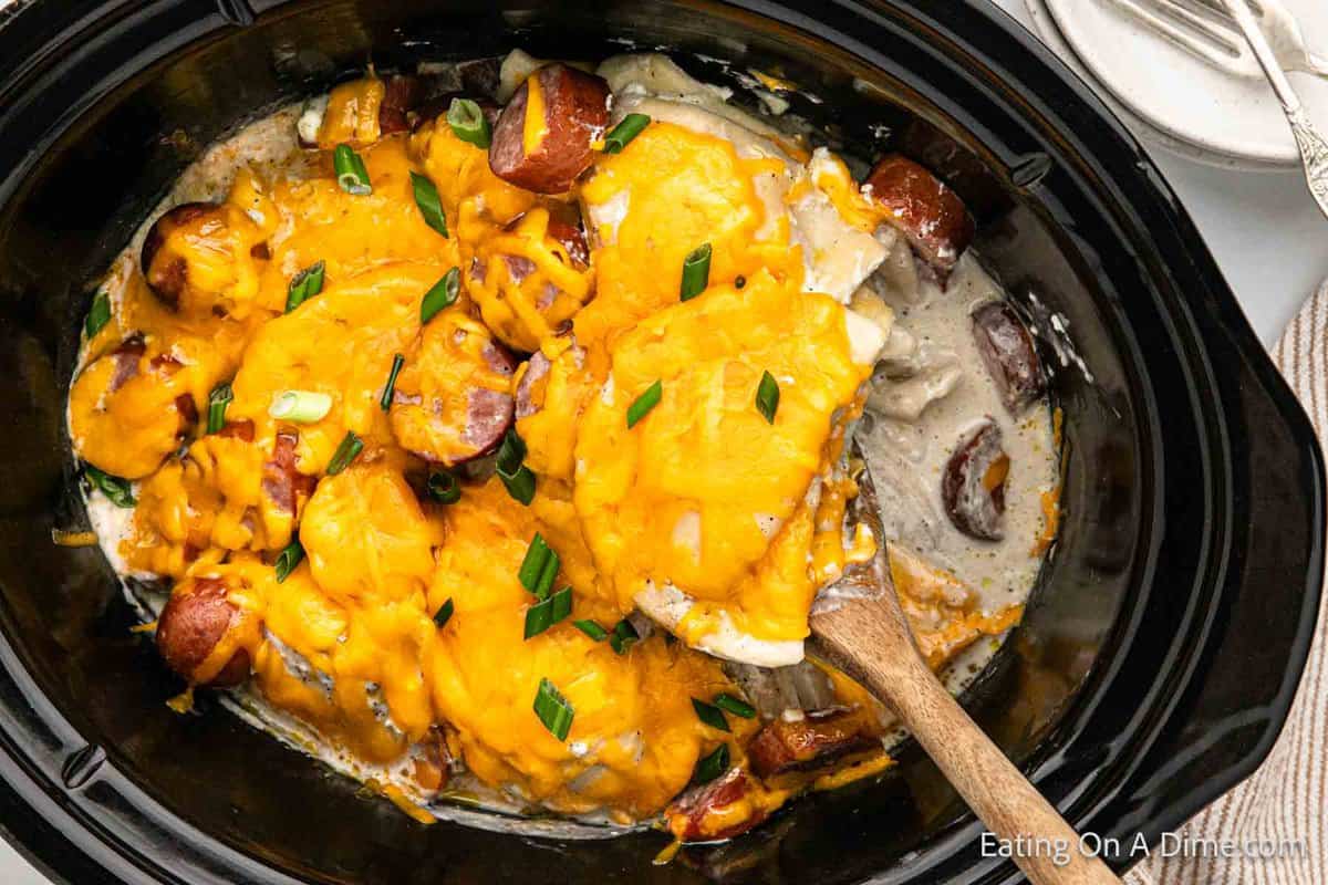 Close up image Pierogi Casserole in the crock pot with a wooden spoon