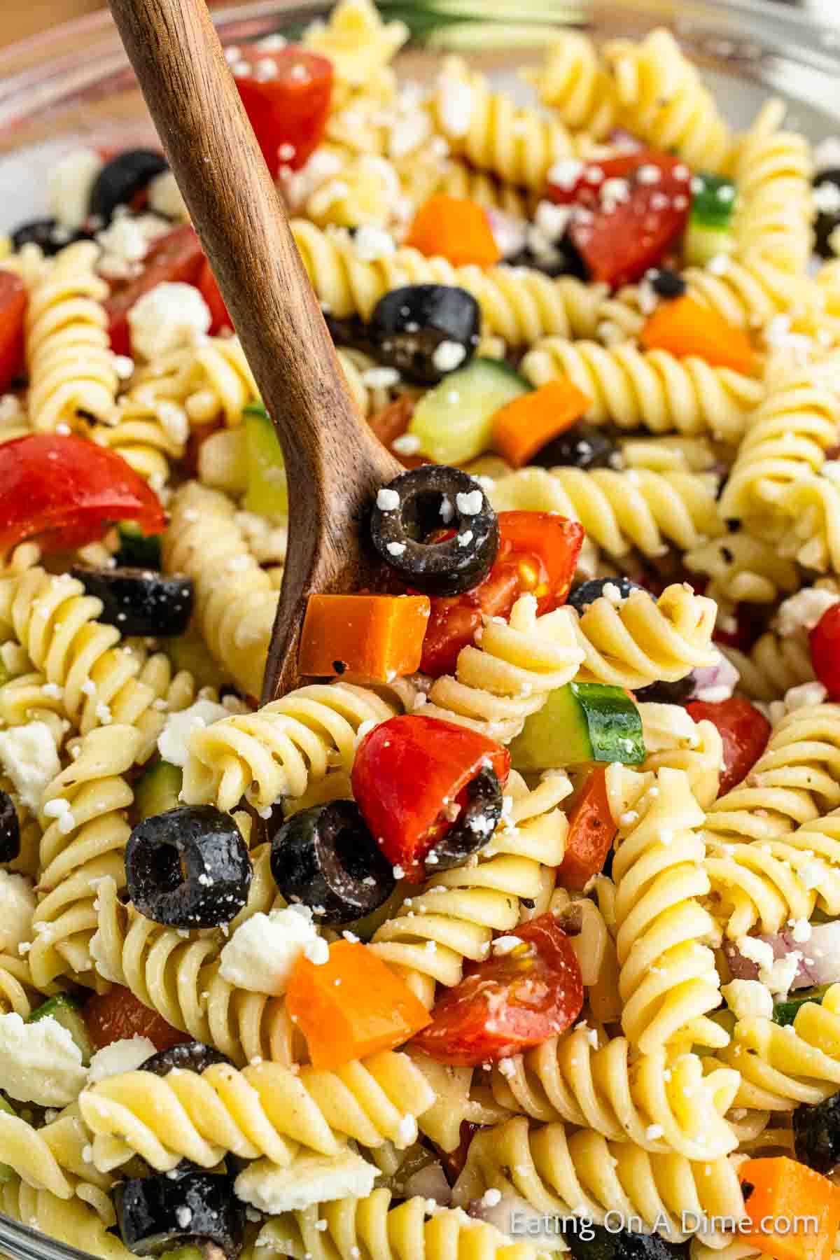 Greek Pasta Salad with a serving on a wooden spoon